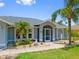 Inviting home with a screened entryway, well-kept lawn, and lush, tropical landscaping at 7183 Spinnaker Blvd, Englewood, FL 34224
