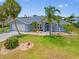 Attractive home with attached garage, palm trees, and a well-manicured lawn at 7183 Spinnaker Blvd, Englewood, FL 34224