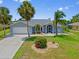 Lovely home with attached garage, palm trees, flower beds and well-maintained lawn at 7183 Spinnaker Blvd, Englewood, FL 34224