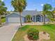 Charming home with a well-manicured lawn, lush palm trees, and beautiful landscaping at 7183 Spinnaker Blvd, Englewood, FL 34224