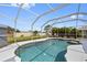 Refreshing pool with a screened enclosure, surrounded by lush greenery and blue sky at 7183 Spinnaker Blvd, Englewood, FL 34224