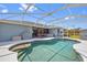 Inviting pool area features a screened enclosure, hot tub, and outdoor dining space at 7183 Spinnaker Blvd, Englewood, FL 34224