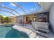 Outdoor living space with a screened pool, hot tub, and dining area under a covered patio at 7183 Spinnaker Blvd, Englewood, FL 34224