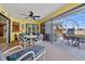 Relaxing screened porch with table and chairs, ceiling fan, and access to the backyard at 7183 Spinnaker Blvd, Englewood, FL 34224