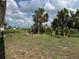 Expansive backyard with mature trees and remnants of landscaping, offering potential for customization at 8158 Trionfo Ave, North Port, FL 34287