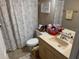 Bathroom with a toilet, sink, mirror, and shower curtain at 8158 Trionfo Ave, North Port, FL 34287