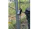 A lockbox hanging on a metal gate next to a trashcan at 8158 Trionfo Ave, North Port, FL 34287