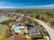 Aerial community view featuring a pool, clubhouse, lush landscaping and various water features, offering resort-style living at 8866 Tuscany Isles Dr, Punta Gorda, FL 33950