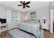 Relaxing bedroom features ceiling fan, paisley bedding, side tables with lamps, and scenic palm tree art at 8866 Tuscany Isles Dr, Punta Gorda, FL 33950
