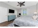 Comfortable bedroom with a ceiling fan, a dresser, a television, and a desk with a computer at 8866 Tuscany Isles Dr, Punta Gorda, FL 33950