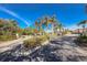 Community entrance with a palm tree lined roundabout and lush greenery, creating a welcoming ambiance at 8866 Tuscany Isles Dr, Punta Gorda, FL 33950