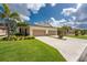 Beautiful townhome with a two-car garage, lush lawn, and tropical landscaping at 8866 Tuscany Isles Dr, Punta Gorda, FL 33950