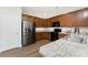 Open kitchen features stainless steel appliances, granite countertops, wood cabinets, and light-colored floors at 8866 Tuscany Isles Dr, Punta Gorda, FL 33950