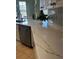A kitchen counter with modern finishes, white cabinetry, backsplash, and stainless steel dishwasher at 96 Vivante Blvd # 9622, Punta Gorda, FL 33950