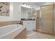 Well-lit bathroom featuring a soaking tub, tile shower, and vanity with black countertop at 99 Vivante Blvd # 310, Punta Gorda, FL 33950