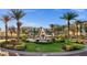 Beautiful community fountain with lush landscaping, mature palms and multi-story buildings in the background at 99 Vivante Blvd # 310, Punta Gorda, FL 33950