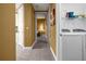 Hallway with tile flooring, leading to a laundry room and a living space filled with sunlight at 99 Vivante Blvd # 310, Punta Gorda, FL 33950