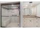 Dual view of a bathroom with a glass door shower and vanity with granite counters and cream cabinets at 1 Colony Point Dr # B20, Punta Gorda, FL 33950