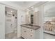 Bathroom with granite countertops, white cabinetry, and seamless access to the primary bedroom at 1 Colony Point Dr # B20, Punta Gorda, FL 33950