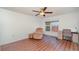 Bedroom with ceiling fan, wood-look flooring, small desk and a window with a view at 1 Colony Point Dr # B20, Punta Gorda, FL 33950