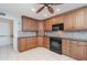 Kitchen features wooden cabinets, tile backsplash, black appliances, and granite countertops at 1 Colony Point Dr # B20, Punta Gorda, FL 33950