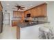 A kitchen with stone countertops, wooden cabinets, tiled backsplash, and modern appliances at 1 Colony Point Dr # B20, Punta Gorda, FL 33950