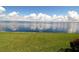 Calm water reflecting a partly cloudy sky; bright green grass in the foreground at 1 Colony Point Dr # B20, Punta Gorda, FL 33950