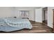 Bedroom with wood floors, a large window with blinds, and a doorway leading to the adjacent room at 1210 Mccrory St, North Port, FL 34286