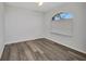 This bedroom has wood floors, a large window with blinds, and white walls at 1210 Mccrory St, North Port, FL 34286