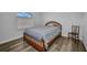 Cozy bedroom features wood-look flooring, a window, a ceiling fan, and classic furnishings at 1210 Mccrory St, North Port, FL 34286