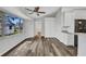 Bright living room boasts wood floors, a ceiling fan, and an abundance of natural light from a large window at 1210 Mccrory St, North Port, FL 34286