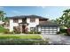 Elegant two-story home boasts lush landscaping, a stylish garage door, and a welcoming front entrance at 12299 Albrecht Ter, Port Charlotte, FL 33981