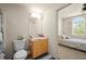 Cozy bathroom featuring a single sink vanity, adjacent to a bedroom with a large window and bed at 1236 Rio De Janeiro Ave # 406, Punta Gorda, FL 33983