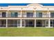 Building exterior with patios enclosed with screens and green lawn in the backyard at 1236 Rio De Janeiro Ave # 406, Punta Gorda, FL 33983