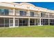 Back of building featuring outdoor patios with screened-in enclosures and green lawn at 1236 Rio De Janeiro Ave # 406, Punta Gorda, FL 33983