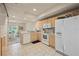 Well-lit kitchen featuring white appliances, wooden cabinets, and an open layout to the dining area at 1236 Rio De Janeiro Ave # 406, Punta Gorda, FL 33983