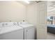 Convenient laundry room featuring a white washer and dryer with access to a bedroom at 1236 Rio De Janeiro Ave # 406, Punta Gorda, FL 33983