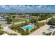 An aerial image showcases a community pool surrounded by a parking area, lush tropical landscaping and nearby residences at 1236 Rio De Janeiro Ave # 406, Punta Gorda, FL 33983