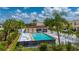 Overhead shot of a community pool with lounge chairs, set amongst lush greenery and palm trees on a sunny day at 1236 Rio De Janeiro Ave # 406, Punta Gorda, FL 33983