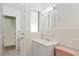 Bright bathroom featuring a white sink vanity, tile walls, and new light fixture above at 125 Small Se St, Port Charlotte, FL 33952
