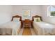 Cozy bedroom with twin beds, natural light, and woven textures for a relaxing atmosphere at 125 Small Se St, Port Charlotte, FL 33952