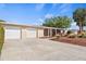 A single-story home featuring a spacious driveway, two-car garage, manicured lawn, and mature trees at 125 Small Se St, Port Charlotte, FL 33952