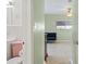 Hallway looking into bedroom with full bath on the left, classic terrazzo, and soft green paint at 125 Small Se St, Port Charlotte, FL 33952