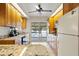 Bright kitchen with wood cabinets, stone countertops, and sliding glass doors to the pool area at 125 Small Se St, Port Charlotte, FL 33952