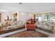 Spacious living room with terrazzo floors, a ceiling fan, and a dining area with a view at 125 Small Se St, Port Charlotte, FL 33952