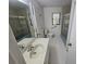 Clean bathroom featuring a shower, commode, and vanity with solid surface countertops and white tiling at 1318 San Mateo Dr, Punta Gorda, FL 33950