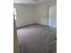 A bright bedroom with neutral carpet, a ceiling fan, and sliding glass door to outdoor space at 1318 San Mateo Dr, Punta Gorda, FL 33950
