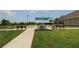 Community bocce court with shady tables for residents' enjoyment, surrounded by green grass and manicured landscaping at 13256 Creekside Ln, Port Charlotte, FL 33953