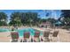 Enjoy the community pool with sun loungers and lush landscaping, creating a tranquil oasis for residents at 13256 Creekside Ln, Port Charlotte, FL 33953