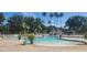 Resort-style community pool with palm trees, comfortable lounge chairs, and a covered pool house for relaxing at 13256 Creekside Ln, Port Charlotte, FL 33953